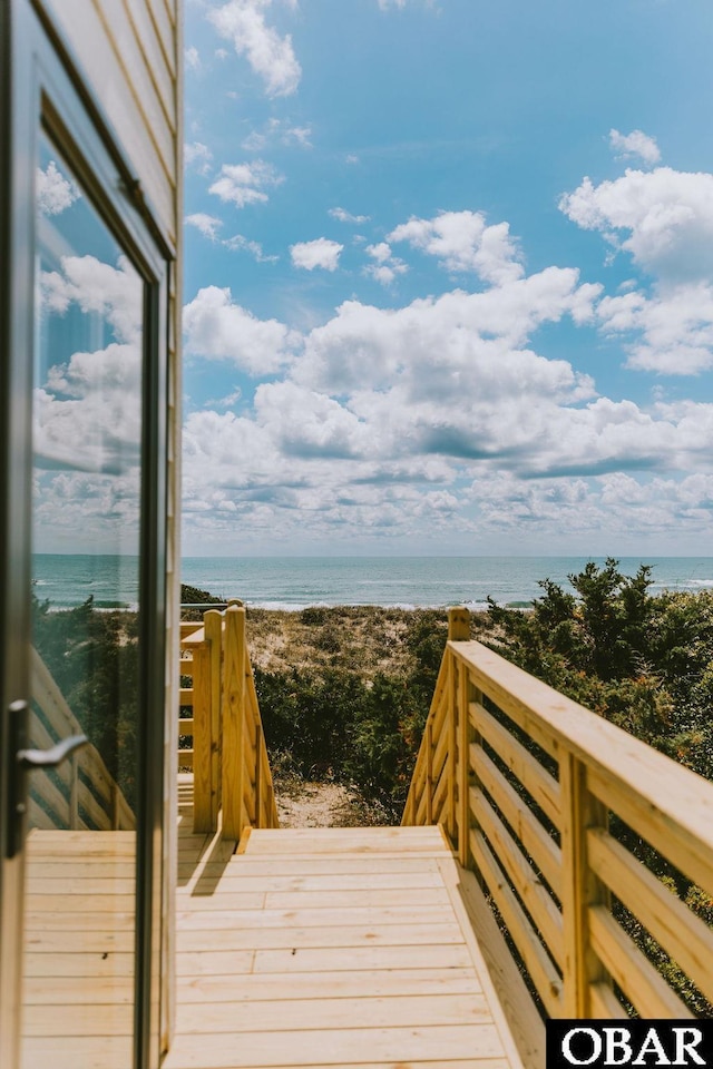 deck featuring a beach view and a water view