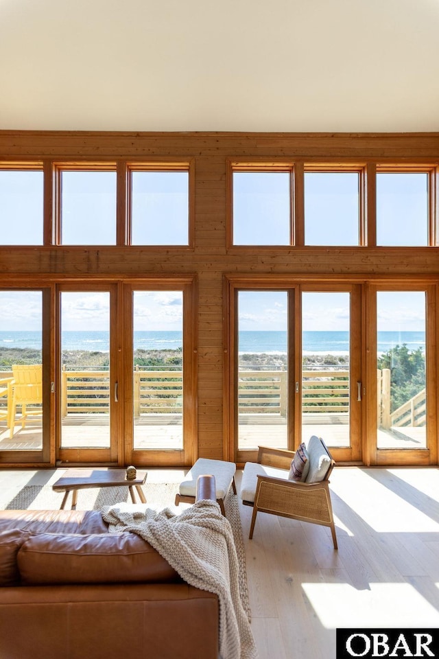 bedroom with wood finished floors, a water view, and access to exterior