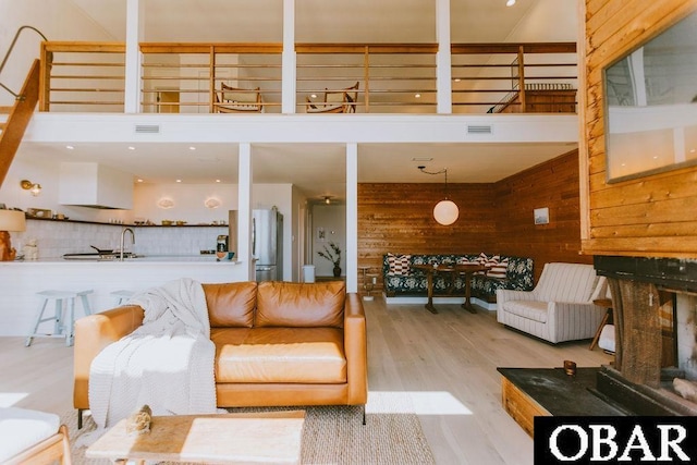 living area featuring visible vents, wood finished floors, and wooden walls