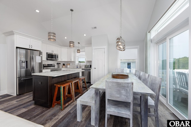 1206 Windance Ln Lot 103, Corolla, NC 27927 - kitchen with appliances with stainless steel finishes, a kitchen island, dark wood finished floors, backsplash, and white cabinets