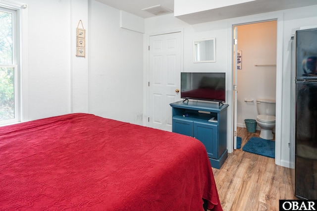 631 Skimmer Ct Lot 17, Corolla, NC 27927 - bedroom featuring light wood-style flooring, freestanding refrigerator, and ensuite bathroom