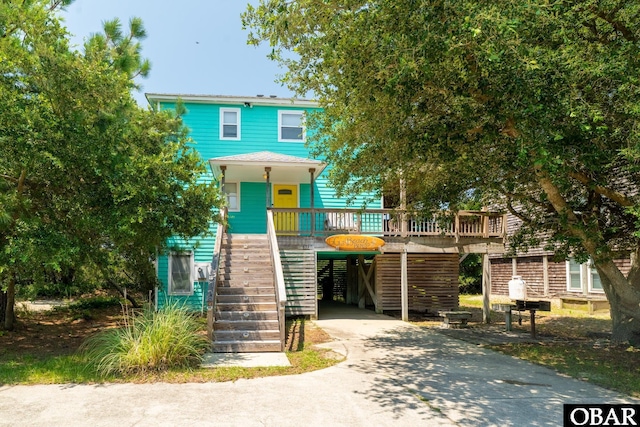 631 Skimmer Ct Lot 17, Corolla, NC 27927 - view of front of home featuring stairs, concrete driveway, a carport, and a porch