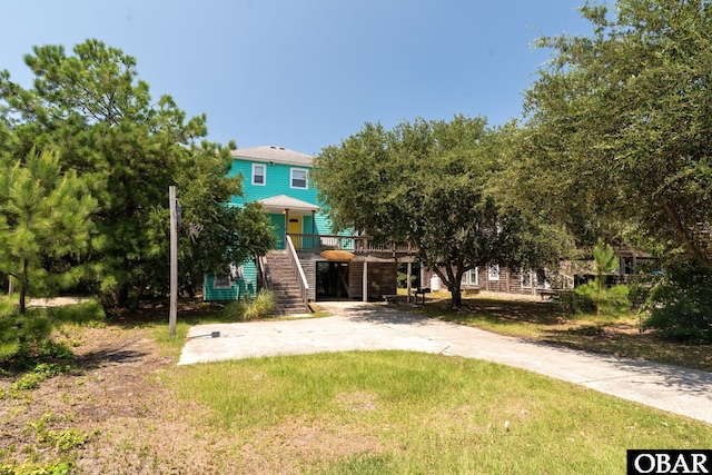 631 Skimmer Ct Lot 17, Corolla, NC 27927 - view of green lawn featuring stairway and concrete driveway