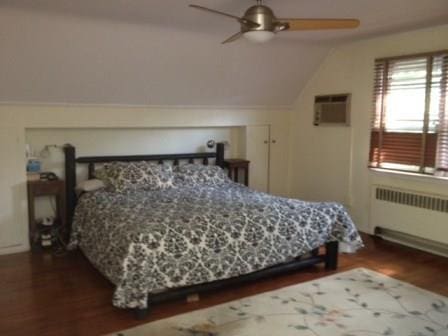 bedroom featuring ceiling fan, dark wood-type flooring, radiator, and lofted ceiling