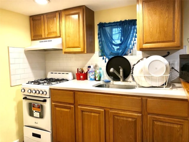 kitchen with sink, backsplash, and white gas stove