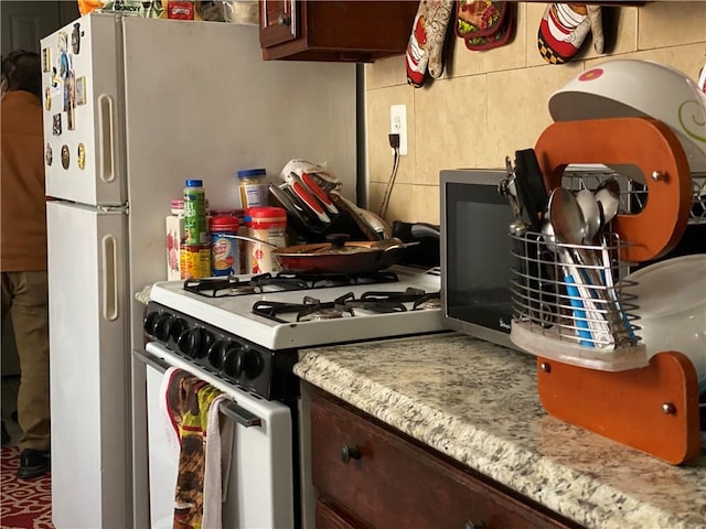 kitchen with dark brown cabinetry and range with gas stovetop