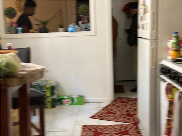 interior space with white gas range and light tile patterned floors