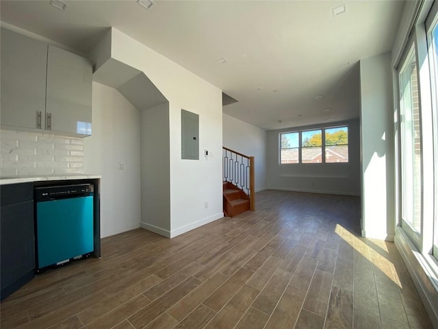 interior space featuring backsplash, dishwasher, hardwood / wood-style flooring, electric panel, and white cabinetry