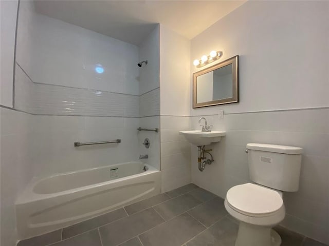 full bathroom with shower / washtub combination, tile patterned flooring, tile walls, toilet, and sink