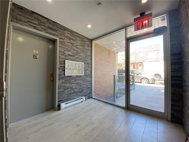 entryway with hardwood / wood-style floors, a baseboard radiator, and a healthy amount of sunlight