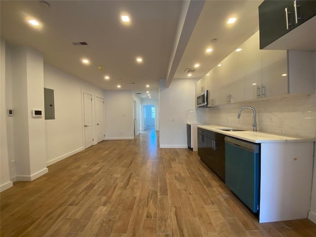 kitchen with stainless steel appliances, sink, hardwood / wood-style floors, and tasteful backsplash