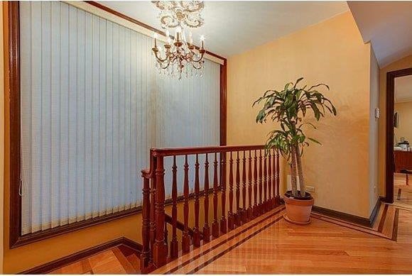 1366 70th St, Brooklyn, NY 11228 - hallway featuring an upstairs landing, a chandelier, baseboards, and parquet floors
