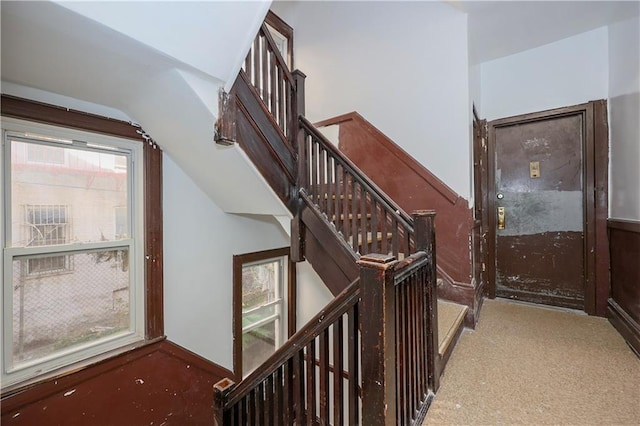 staircase with a wealth of natural light and vaulted ceiling