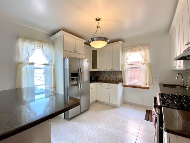 kitchen with white cabinetry, sink, stainless steel appliances, tasteful backsplash, and decorative light fixtures