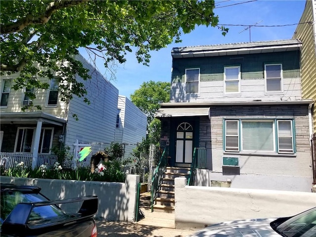 view of front facade with a fenced front yard and brick siding