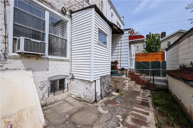 view of side of home featuring fence and cooling unit