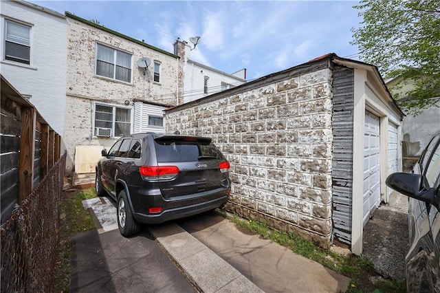 view of side of home with a garage and fence