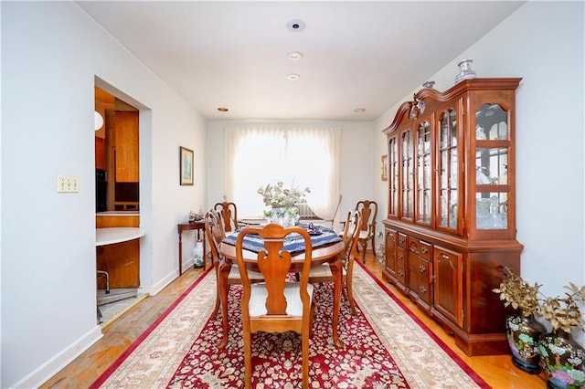 dining room with light wood-style flooring, baseboards, and recessed lighting