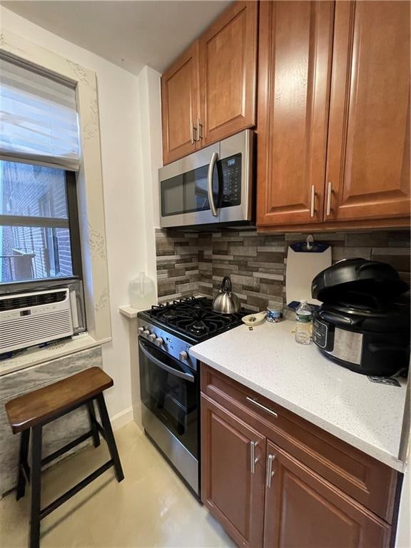 kitchen featuring backsplash, light stone countertops, cooling unit, and appliances with stainless steel finishes