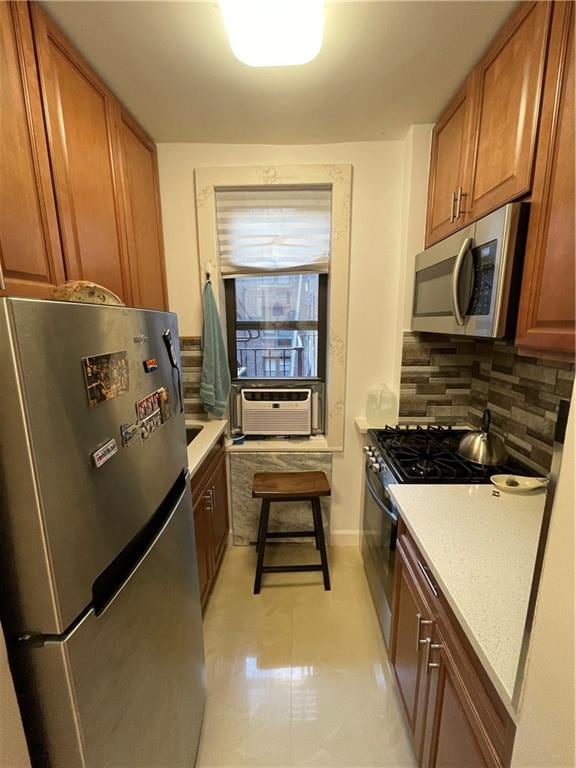 kitchen with light stone countertops, backsplash, and stainless steel appliances