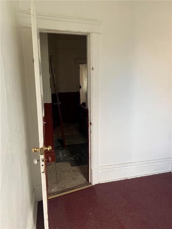 corridor featuring dark colored carpet