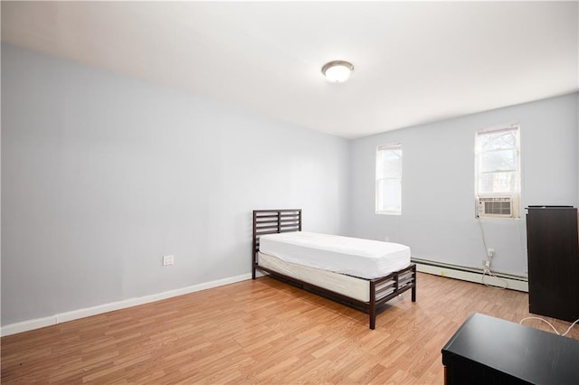 bedroom with cooling unit, light wood-style flooring, a baseboard heating unit, and baseboards