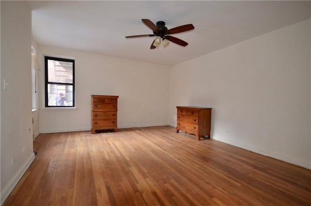 spare room with light wood finished floors and ceiling fan