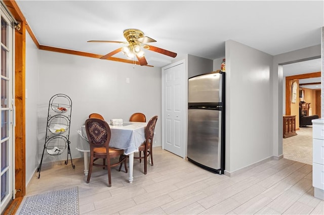 dining area with ceiling fan, light wood-type flooring, and baseboards