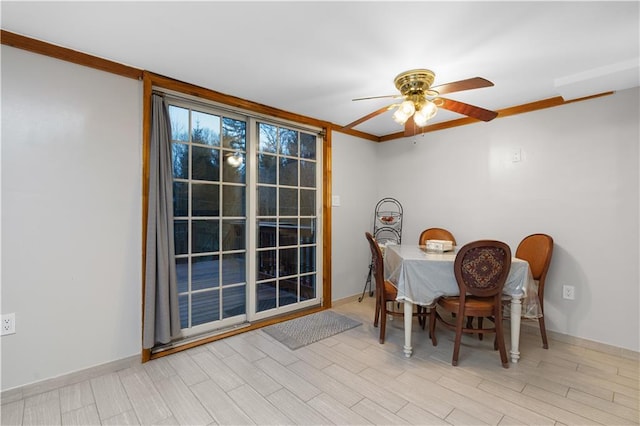 dining room featuring light wood-style floors, baseboards, and a ceiling fan