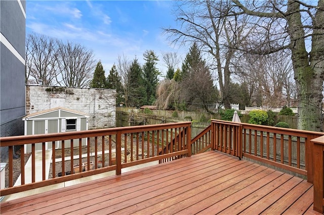 wooden deck with a storage shed, a fenced backyard, and an outdoor structure