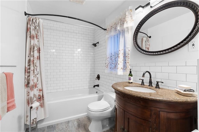 full bath with shower / tub combo with curtain, tile walls, toilet, vanity, and wood finished floors