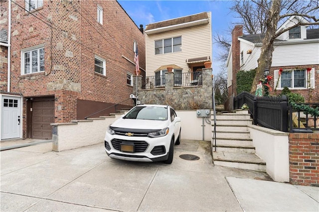 view of front facade featuring a garage, stairs, and concrete driveway