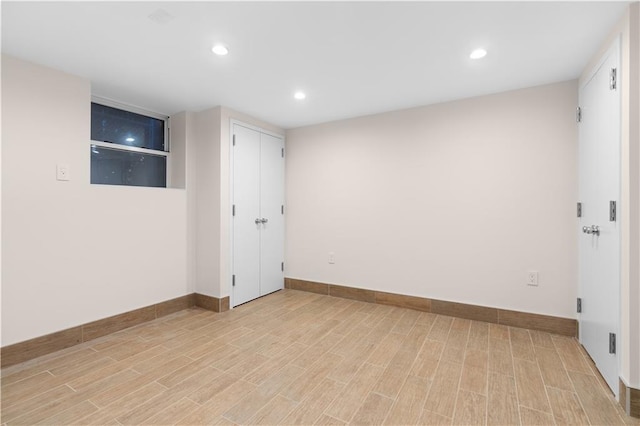 empty room featuring light wood-type flooring, baseboards, and recessed lighting