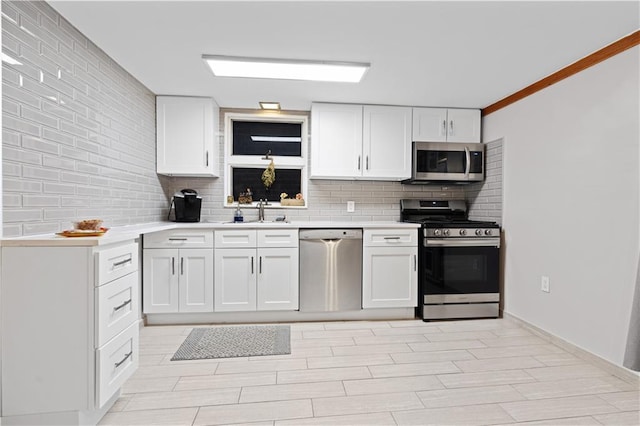 kitchen featuring a sink, white cabinetry, light countertops, appliances with stainless steel finishes, and decorative backsplash