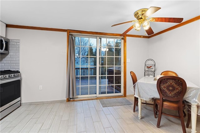 dining area featuring ornamental molding, light wood-style floors, baseboards, and ceiling fan