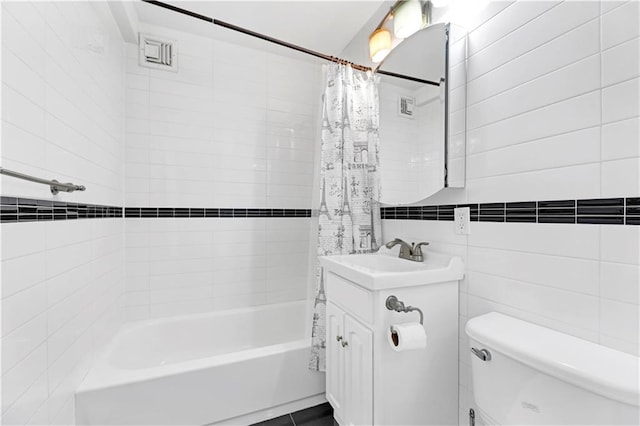 full bathroom featuring vanity, toilet, shower / bathtub combination with curtain, and tile walls