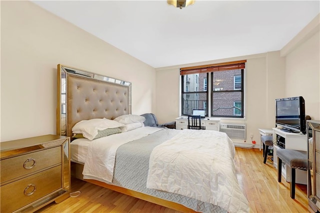 bedroom featuring light wood-type flooring and a wall unit AC