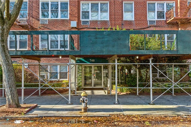 exterior space with cooling unit, french doors, and brick siding