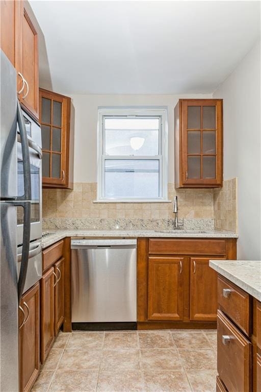 kitchen featuring glass insert cabinets, brown cabinets, and dishwasher