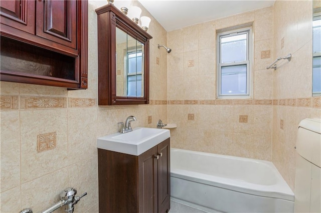 bathroom with shower / washtub combination, vanity, and tile walls