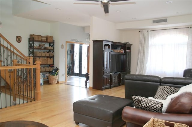 living room featuring ceiling fan and light hardwood / wood-style flooring