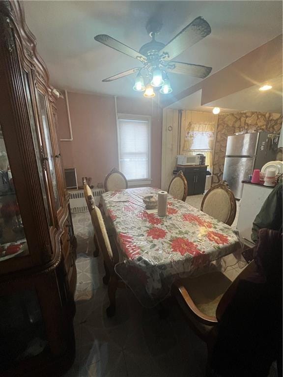 dining room with ceiling fan and radiator