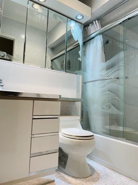 full bathroom with toilet, vanity, and shower / bath combination with glass door