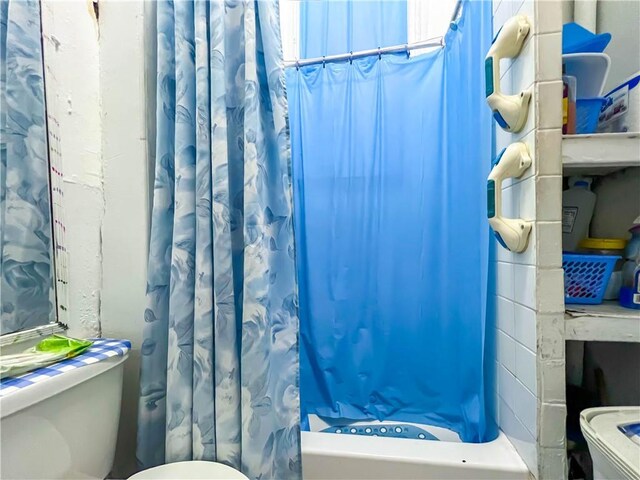 bathroom with toilet and shower / bath combo with shower curtain