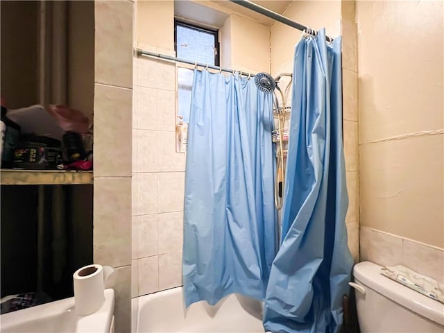 bathroom featuring shower / bath combination with curtain and toilet