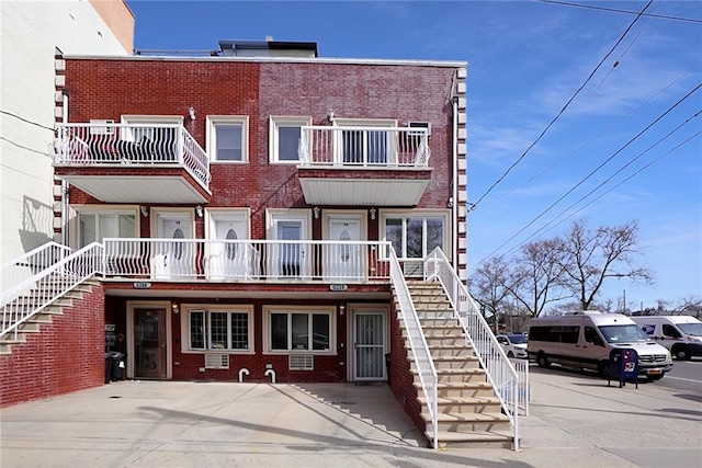 view of front facade with brick siding and stairway
