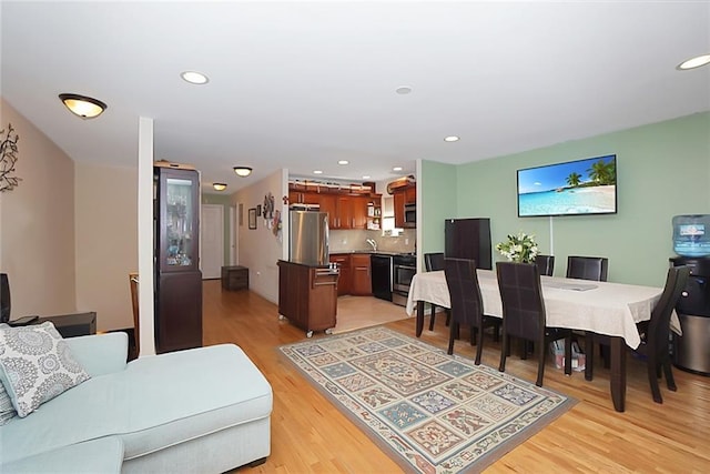 living area with light wood-style flooring and recessed lighting