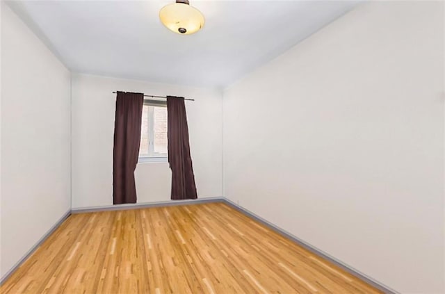 unfurnished room with wood finished floors and baseboards
