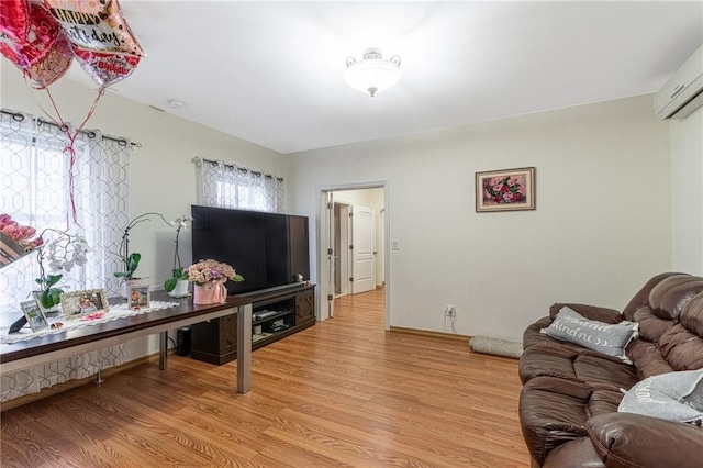 living room featuring light hardwood / wood-style floors and an AC wall unit