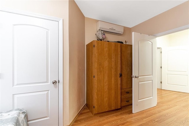 interior space with light hardwood / wood-style floors and a wall unit AC